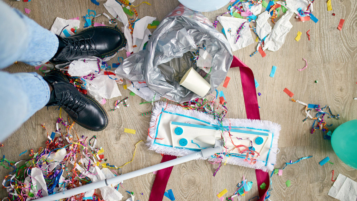 A person standing on a floor surrounded by confetti and confetti sticks