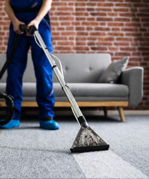 A man is using a vacuum to clean the carpet